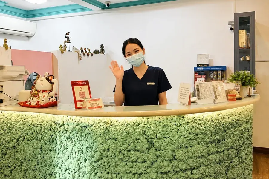 A staff member at the reception desk of FTS Chin Dental in Plaza Juta Likas, Kota Kinabalu