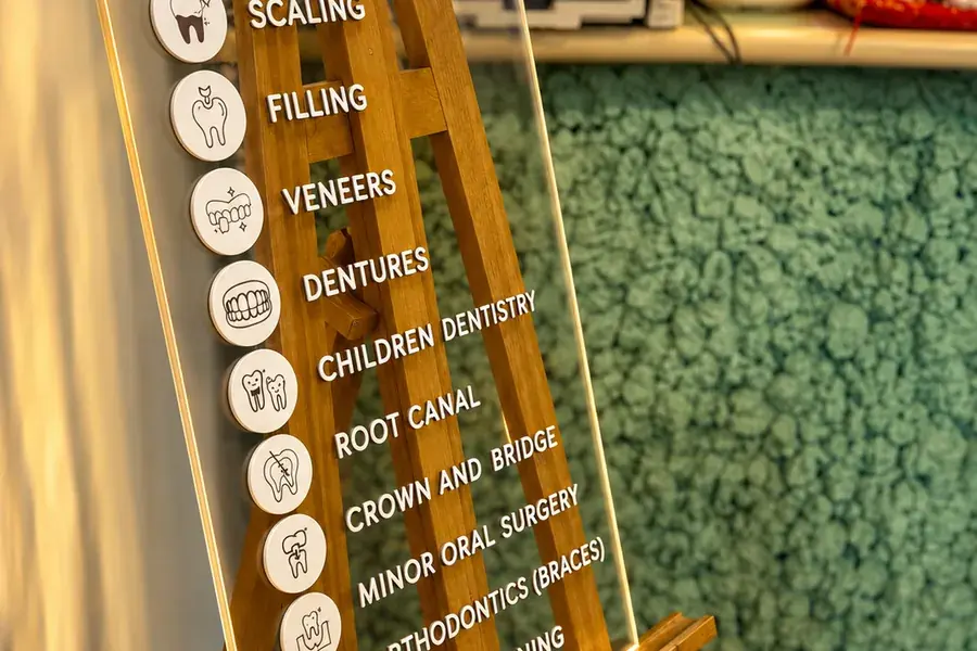 A board at FTS Chin Dental listing the treatments offered, from scaling to orthodontics
