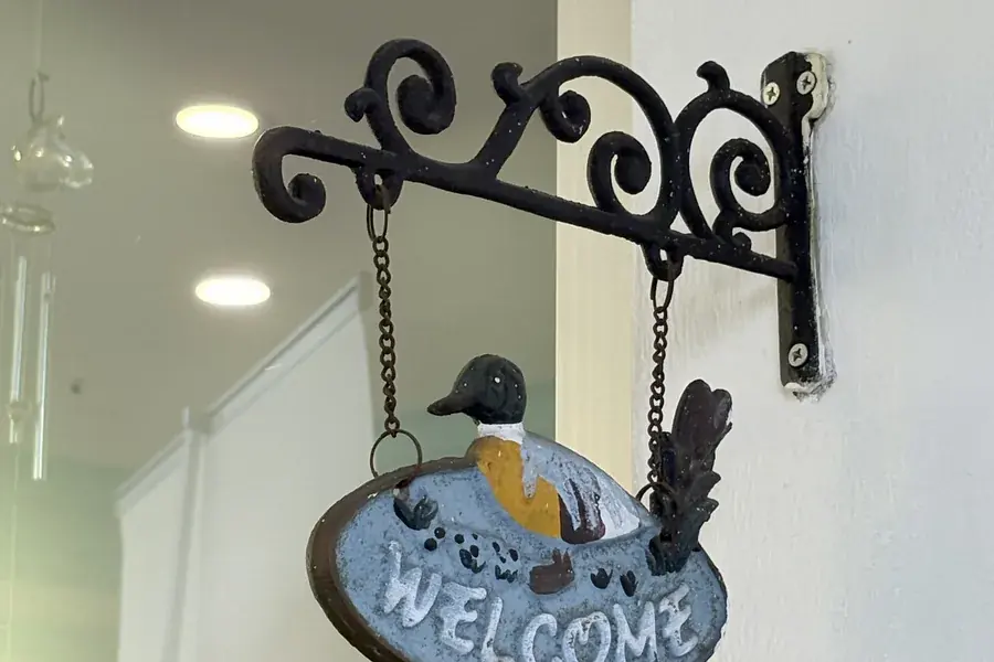 A hand-painted welcome sign hanging at the entrance to FTS Chin Dental in Likas